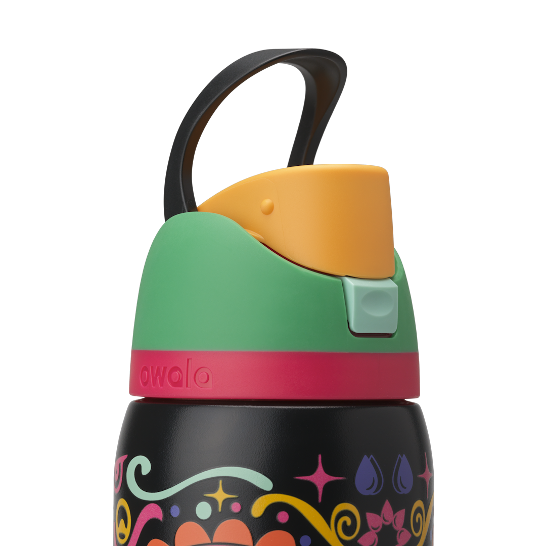 Owala FreeSip Sway 32oz in Sugar Skull, black carry loop raised above green flip cap with orange push-button and pink lid accent ring; glows in the dark